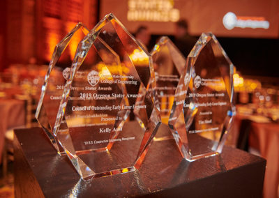 Several glass trophies on a table at a OneSource Strategy alumni event