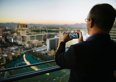 A Man Taking A Photo With His Phone From A Balcony