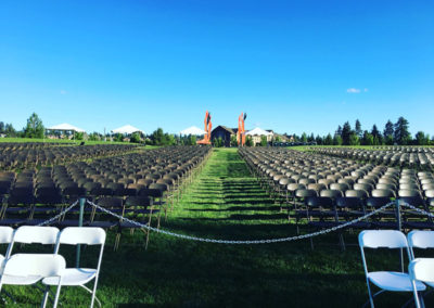 A large arrangement of chairs on a lawn field at a OneSource Strategy higher education ceremony event