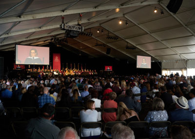 A wide shot of a crowd listening to a speech at a OneSource Strategy higher education ceremony