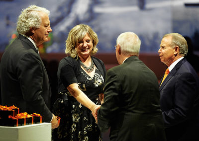 A group of four greet one another at a OneSource Strategy event