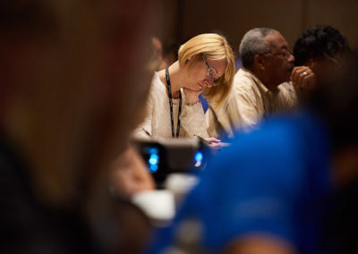 A Woman Taking Notes During a Breakout Session at a OneSource Strategy Event