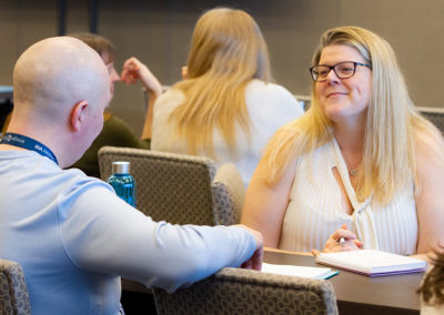 People in discussion during training at a OneSource Strategy association event