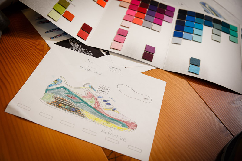A sketch of a shoe design sitting on a table next to color swatches